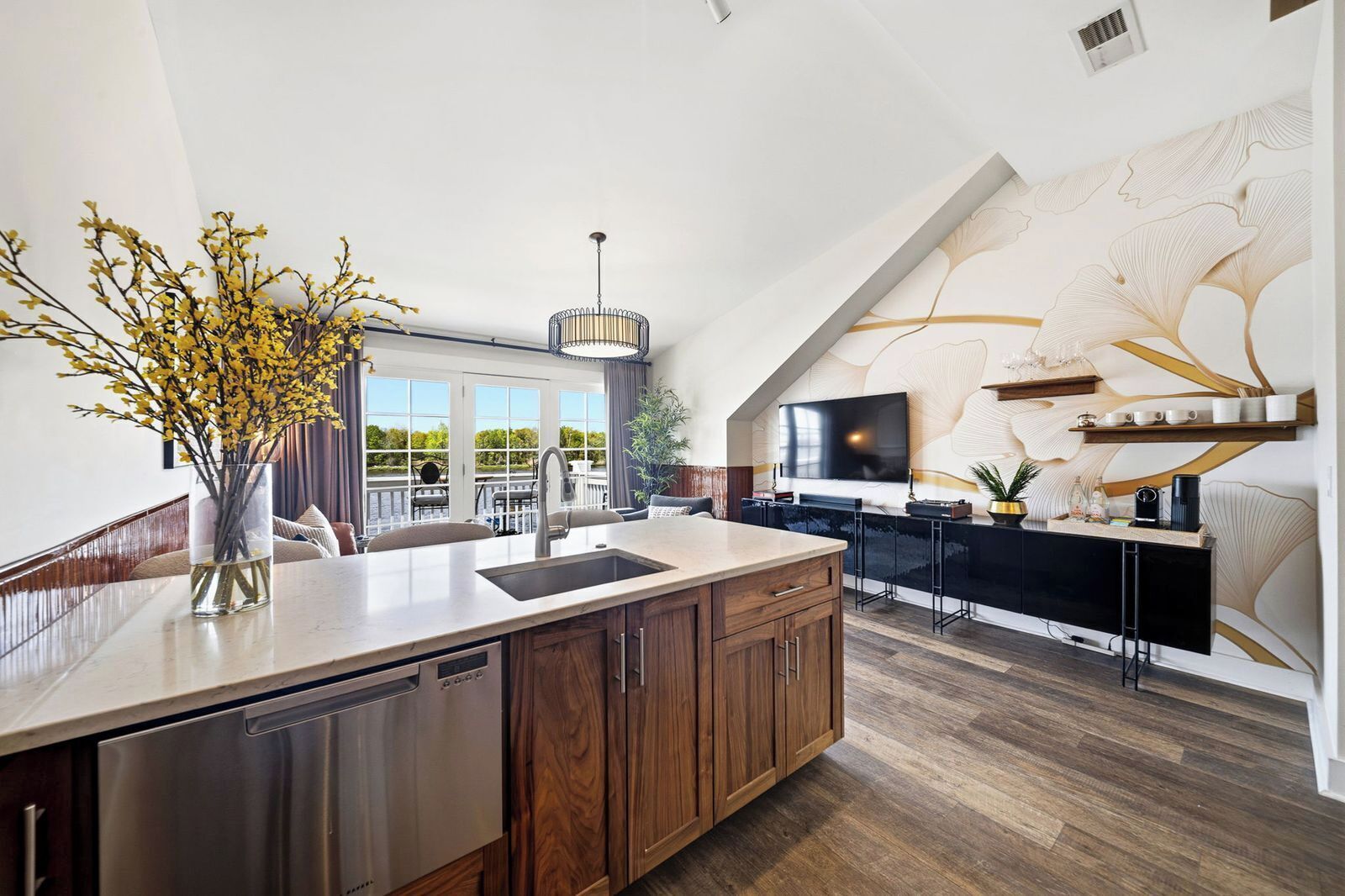 Una cucina moderna con una grande isola, elettrodomestici integrati e un'area pranzo con vista.