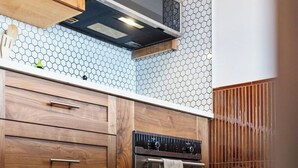A kitchen with wooden cabinets, a microwave, and an oven. - The Lantern Loft | Luxury Riverfront Downtown (Wilmington)