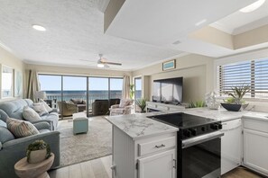 Un salon spacieux avec un grand canapé, un coin repas et une cuisine au design moderne.