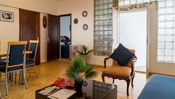 A living room with a dining area, a sofa, a coffee table, and a potted plant. - Casa Tita penthouse with rooftop in downtown Querétaro (Santiago de Querétaro)