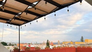 A rooftop terrace with artificial grass, potted plants, and a view of the cityscape. - Casa Tita penthouse with rooftop in downtown Querétaro (Santiago de Querétaro)