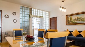 A dining area with a glass-top table, blue chairs, and a bowl of fruit. - Casa Tita penthouse with rooftop in downtown Querétaro (Santiago de Querétaro)