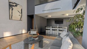 Un soggiorno moderno con un divano grigio, un tavolino rotondo e un quadro appeso al muro.