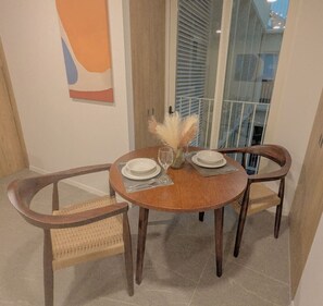 A dining area with a round table, two chairs, and a vase with pampas grass. - Auditorio Telmex • Arcos • Basílica • Museo (Zapopan)