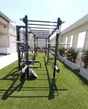 An outdoor gym setup with a pull-up bar, weight bench, and resistance bands on artificial turf. - Zapopan Centro+ Cerca Basílica + Andares + Telmex (Zapopan)