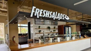Un buffet à salades avec une pancarte indiquant « SALADES FRAÎCHES ».