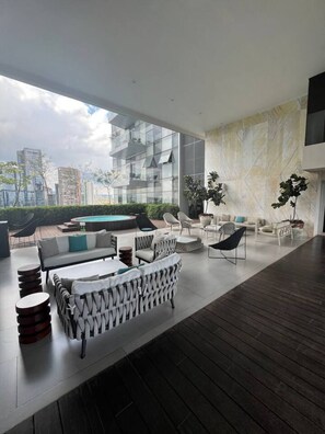 Una sala de estar moderna con piscina, muebles contemporáneos y vistas a la ciudad.