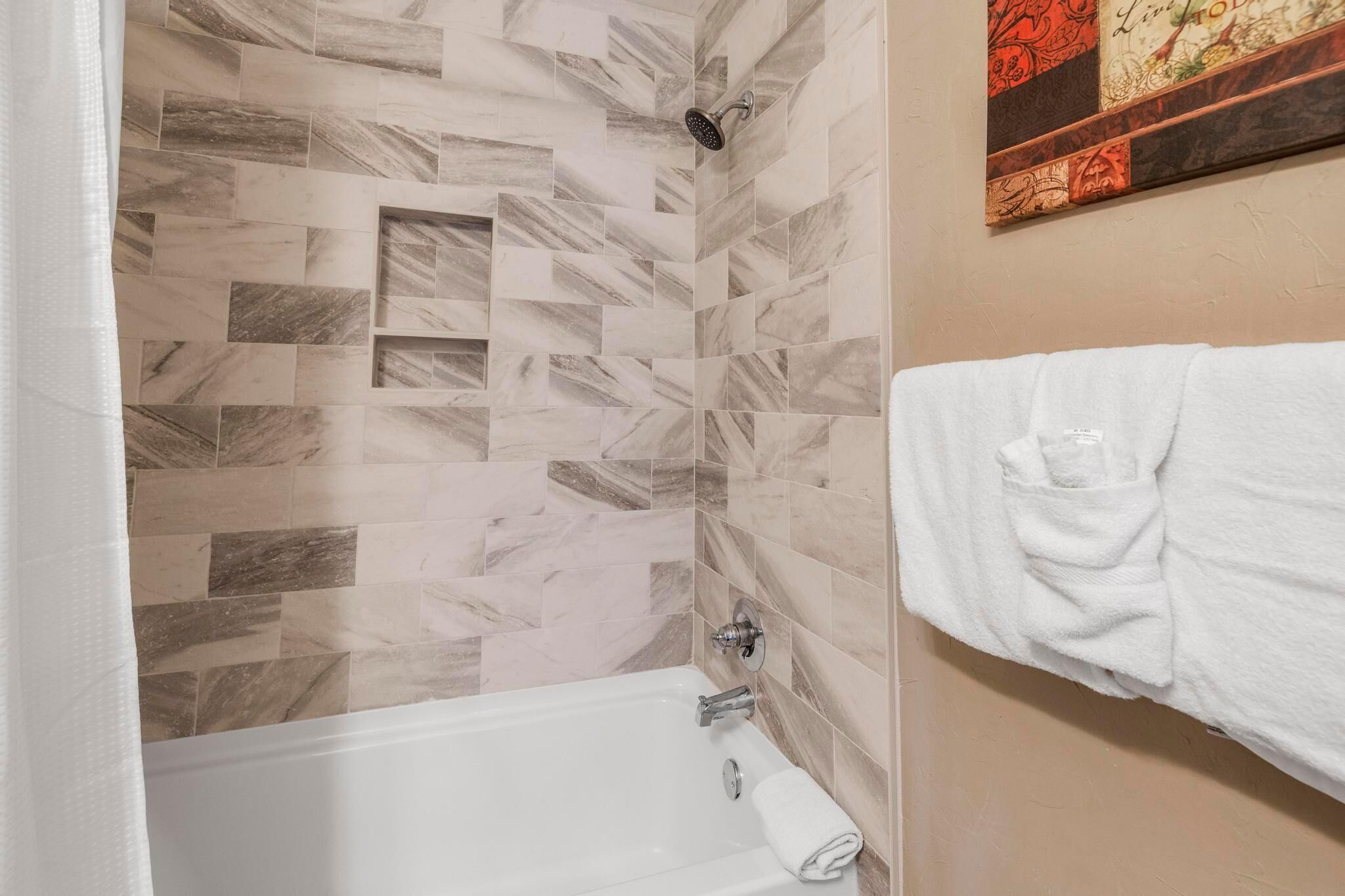 A bathroom with a shower, a bathtub, and a towel rack.