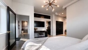 Ein modernes Schlafzimmer mit einem großen Bett, einem Schreibtisch und einem Fernseher.