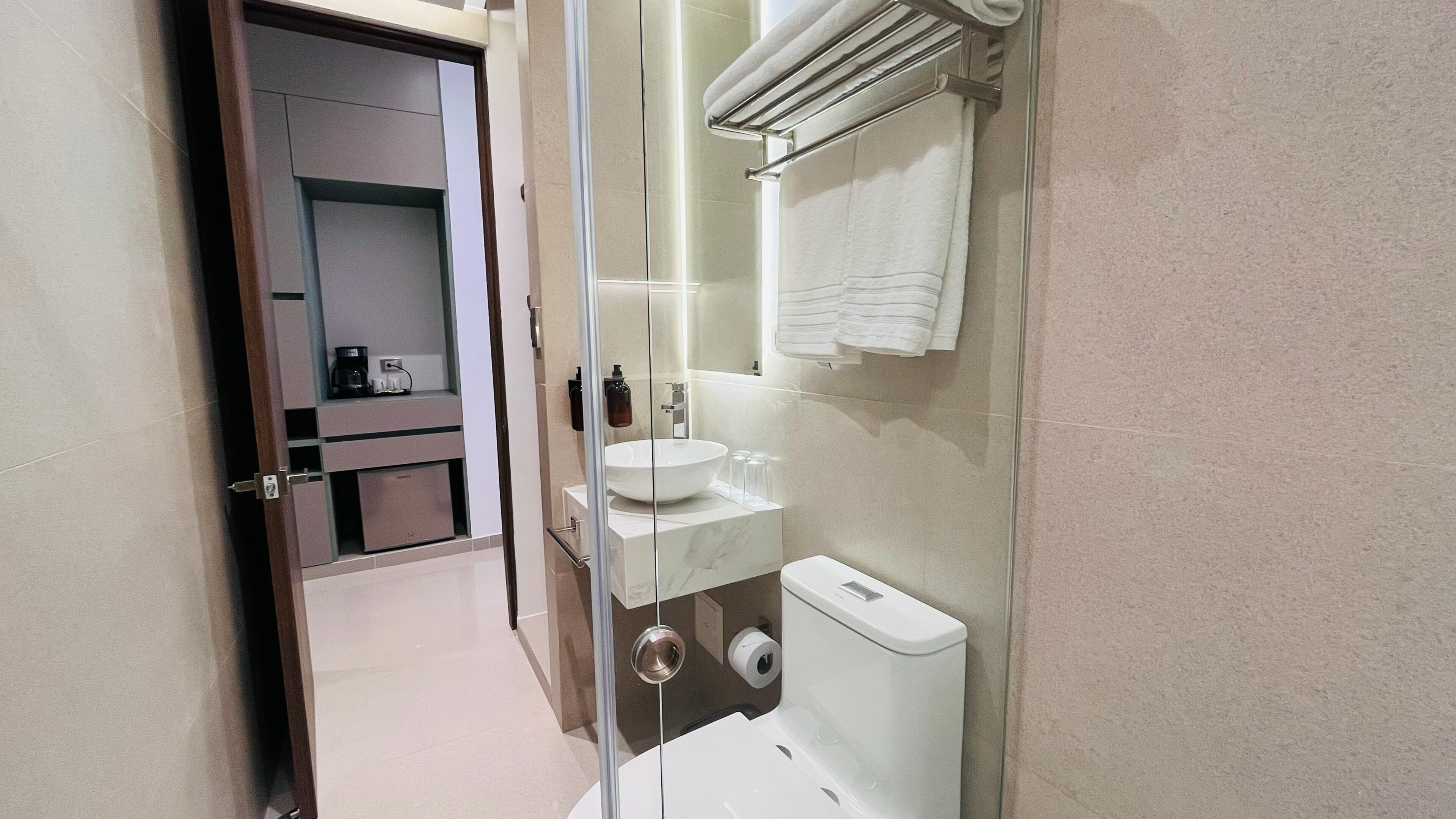 Een moderne badkamer met een douchecabine van glas, een wit wastafelmeubel en een toilet.