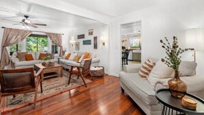 A modern living room with a sofa, armchairs, a coffee table, and a dining table. - Cozy Cottage Mountain Retreat | The Glade Escape (Gatlinburg)