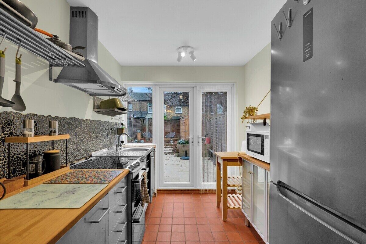 A compact kitchen with a built-in stove, a refrigerator, and a microwave.