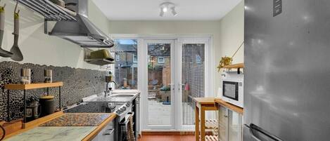 A compact kitchen with a built-in stove, a refrigerator, and a microwave.