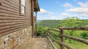 A wooden cabin with a stone foundation, a balcony, and a scenic view of a forested valley. - Rustic Cedar Roost • Private Balcony • Best Views (Jasper)