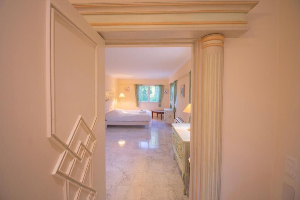 A hotel room with a bed, a small table, and a nightstand.
