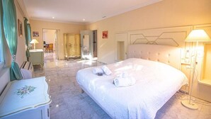 Habitación de hotel con una cama grande, un escritorio y un baño visible a través de una puerta abierta.