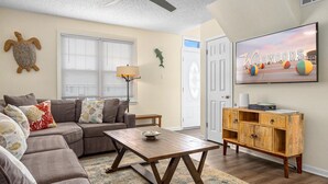 A living room with a sofa, coffee table, and wooden cabinet. - 5BR Beach House in WW Crest - Sleep 12! (Wildwood)