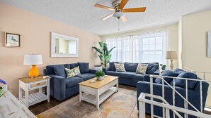 A living room with a ceiling fan, a sofa set, a coffee table, and a side table with a lamp. - 5BR Beach House in WW Crest - Sleep 12! (Wildwood)
