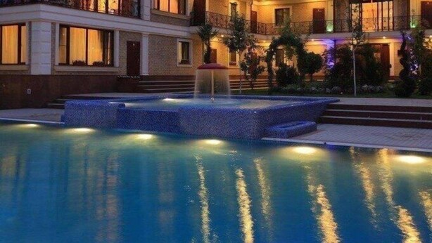 A multi-story hotel with a swimming pool, balconies, and a well-lit exterior. - Sky Town Mountain Resort (Chorvoq)
