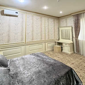 A bedroom with a bed, a dresser, a mirror, and an air conditioning unit. - Sky Town Mountain Resort (Chorvoq)