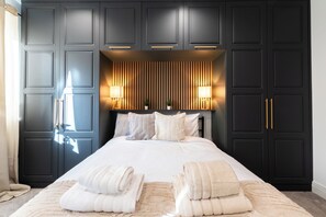 A bedroom with a large bed, dark wooden wardrobe, and two bedside lamps. - Open Mind Property- 6BR Home, Hot Tub & Free Parking (Fareham , PO15 5RS)