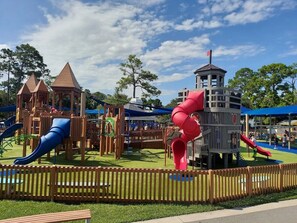A playground with various play structures including slides and climbing areas. - Tropical Sun | Steps to Jax Beach | Bikes Included (Jacksonville Beach)