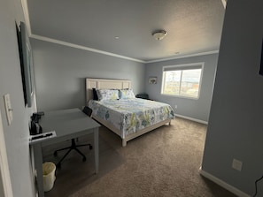 Une chambre à coucher avec un lit, un bureau et une fenêtre.