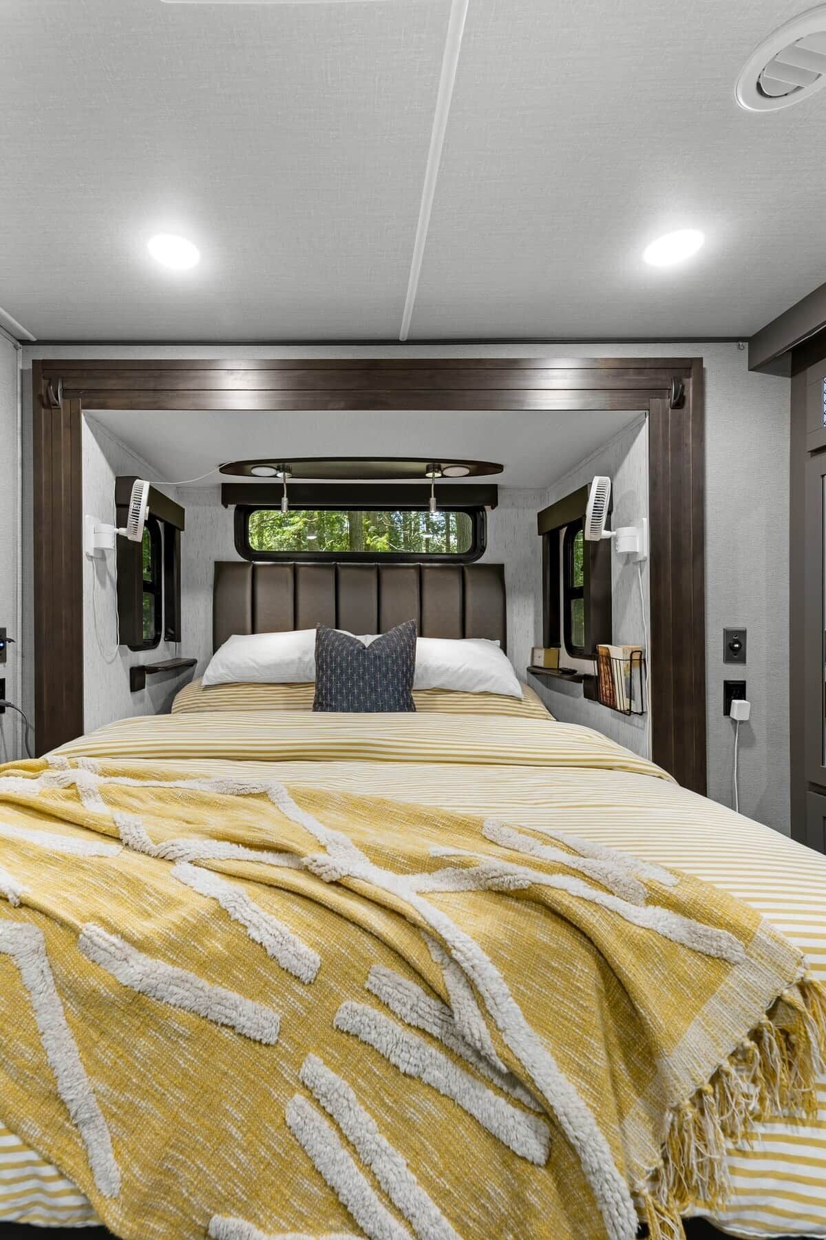 Una camera da letto moderna con un letto grande, una testata, comodini e una finestra con vista.
