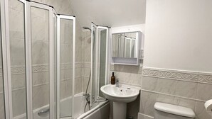 Un baño con bañera, lavabo e inodoro.