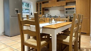 Una cocina moderna con armarios de madera, horno empotrado y refrigerador de acero inoxidable.