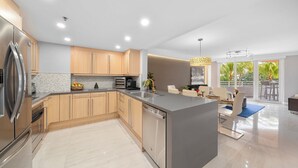Una cocina moderna con electrodomésticos de acero inoxidable, armarios de madera y una isla grande.