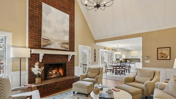 A spacious living room with a fireplace, comfortable seating, and a view into the kitchen. - Quiet retreat in Peachtree Corners (Norcross)