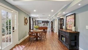 A spacious dining area with a wooden table and chairs, a fireplace, and a view of the outdoors. - Quiet retreat in Peachtree Corners (Norcross)
