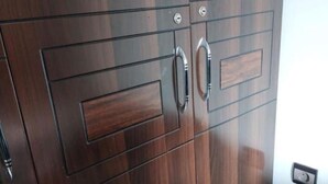 Een houten garderobe met twee lades en twee deuren, elk met een handgreep.