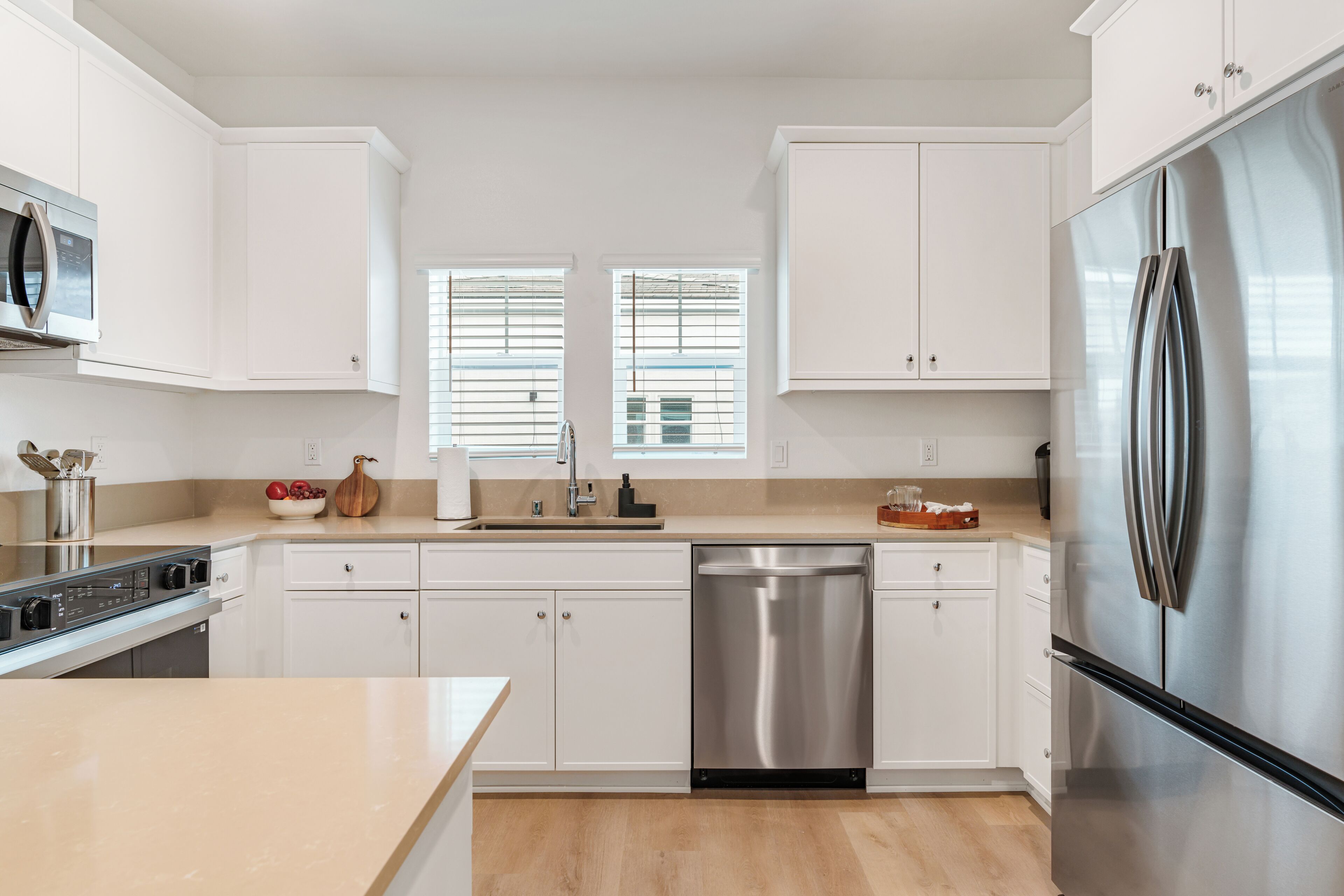 A modern kitchen with white cabinets, stainless steel appliances, and a dishwasher.