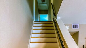 Eine Treppe mit Holzstufen und Geländer, die zu einer Tür oben führt.