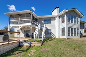 A two-story house with a balcony, a staircase, and a deck. - Lakeside Retreat: Large Spacious Home w/ Game Room (Tool)