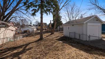 A residential area with detached houses, a fenced yard, and a garage.