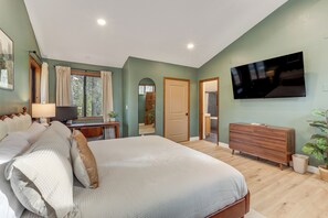 A bedroom with a large bed, a TV mounted on the wall, a dresser, and a window with curtains. - Forest-View Group Getaway, 4 Mi to Dtwn Flagstaff (Flagstaff)