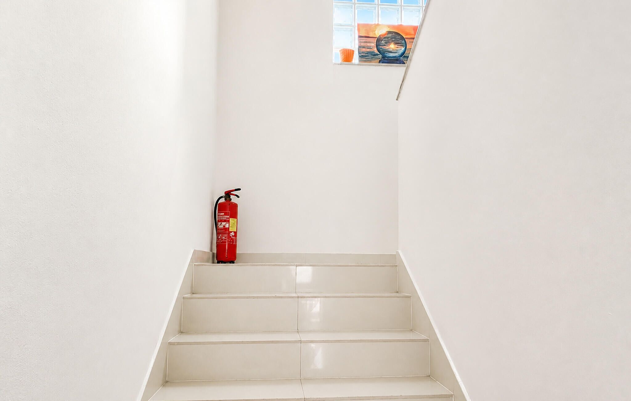 Un escalier avec un extincteur sur la plateforme.