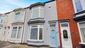 A row of terraced houses with bay windows, a blue door, and a brick facade. - Coastal 3-Bed Home for Families & Contractors (Redcar and Cleveland)