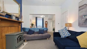 A living room with a fireplace, a sofa, a couch, a chandelier, and a painting on the wall. - Coastal 3-Bed Home for Families & Contractors (Redcar and Cleveland)