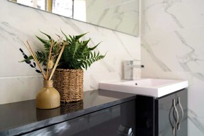 Indulge in relaxation in the main bathroom, featuring a shower over bath, toilet and sink. Fresh towels are provided on arrival. - Norton 2BR Apartment | Sleeps 4 by Stay With Us (Norton)
