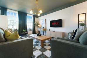 Unwind in a stylish living space designed for comfort, featuring cozy sofa seating, modern décor, and a bright, welcoming atmosphere ideal for relaxing after a day out. - Norton 2BR Apartment | Sleeps 4 by Stay With Us (Norton)