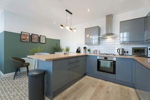 This stylish kitchen includes all the essentials needed for cooking and dining, including an oven, hob, fridge, freezer, microwave, kettle, and toaster. Perfect for everything from quick breakfasts to evening meals. - Norton 2BR Apartment | Sleeps 4 by Stay With Us (Norton)