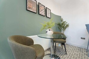 A bright and functional dining area designed for both meals and productivity. Whether enjoying breakfast, sharing dinner, or catching up on work, the space provides a comfortable and welcoming setting throughout your stay. - Norton 2BR Apartment | Sleeps 4 by Stay With Us (Norton)