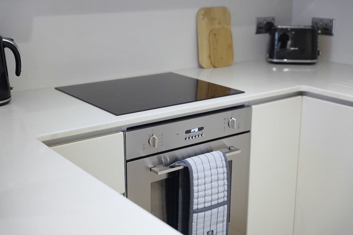 Uma cozinha com forno embutido, fogão e torradeira.