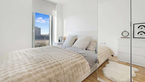 A modern bedroom with a bed, a large window, and a city view. - Manchester 2BR Apartment w/Super Fast WI-FI ! (Greater Manchester)