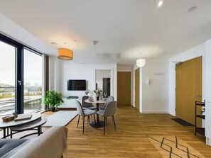 Ein modernes Interieur mit Essbereich, einer Couch und einem Fernseher.