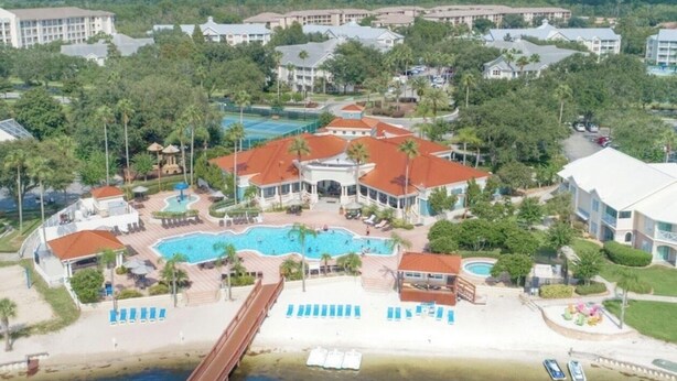 Resort com várias piscinas, área de praia e um píer.